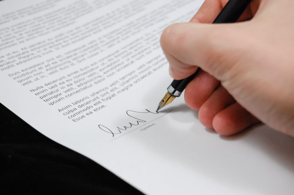 Legal paperwork being signed with a pen